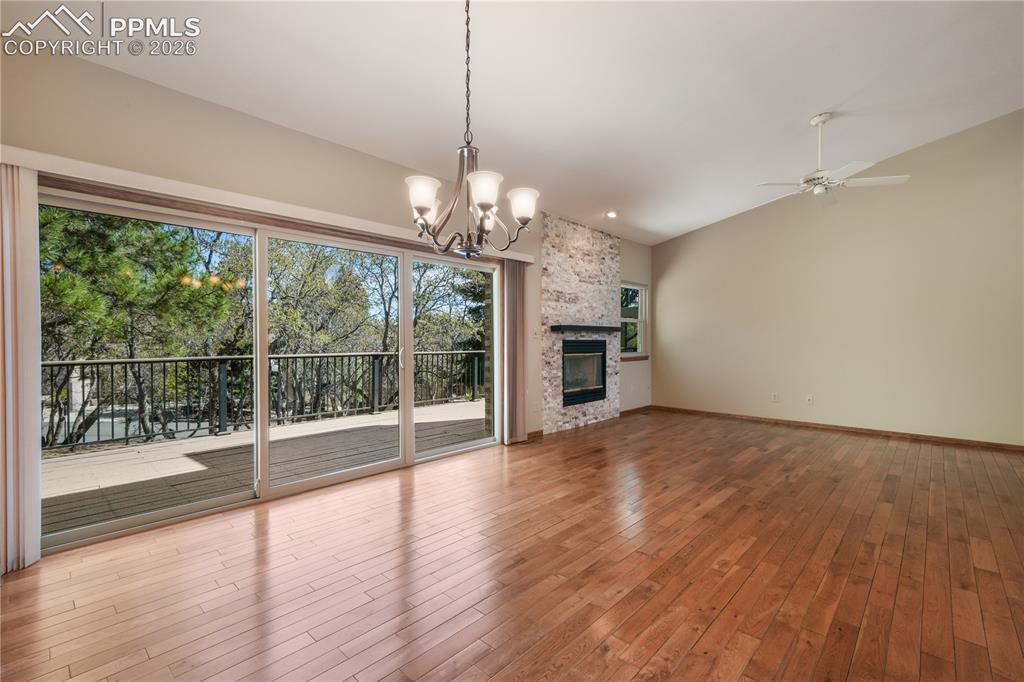 Image 11 of 50: Main living room with hardwood floors, gas fireplace, extended patio doors