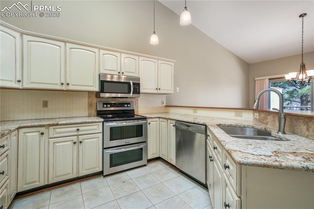 Image 13 of 50: Kitchen with additional bar seating, hard wood floors, updated appliances a