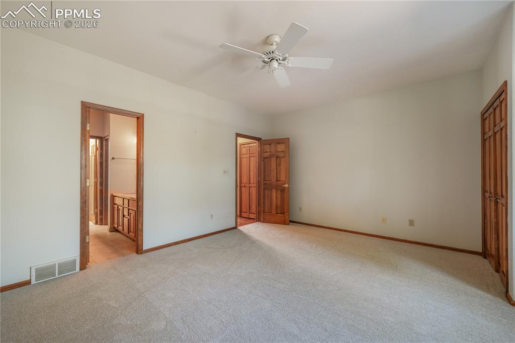 Image 24 of 50: Main level primary bedroom with new carpet, ensuite 5 piece bathroom, walk