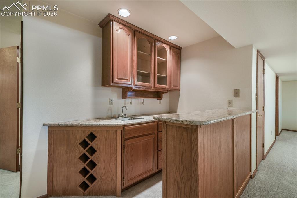 Image 32 of 50: Basement mini bar, refrigerator included, granite countertops