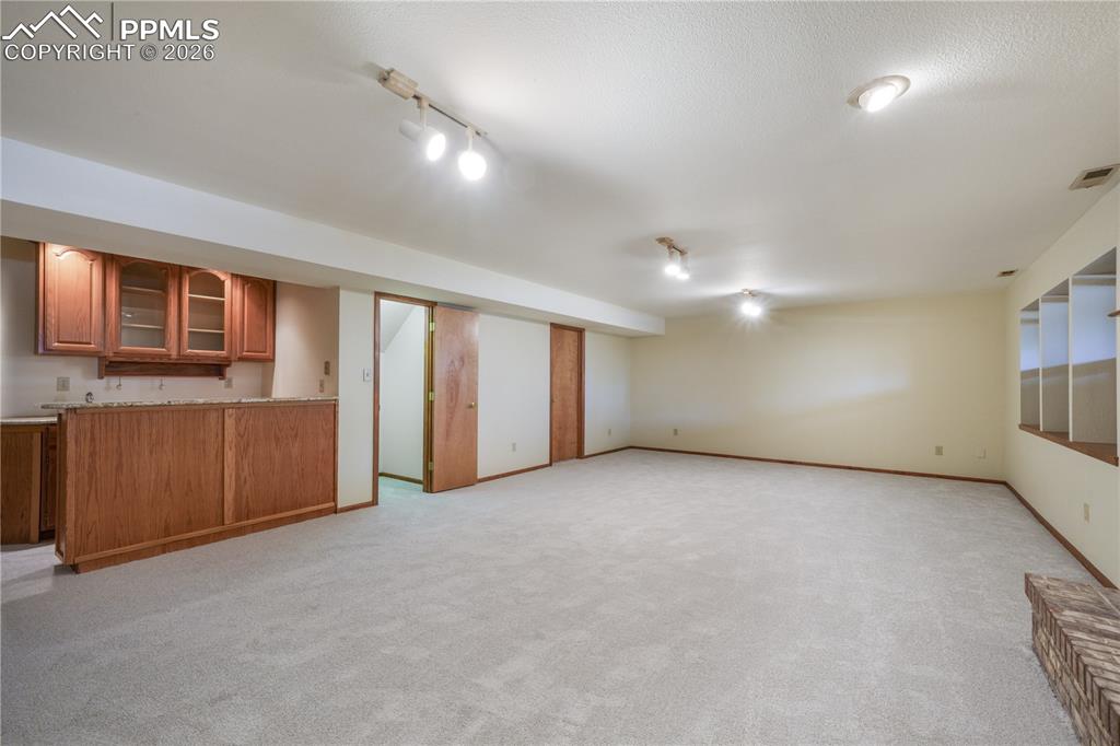 Image 37 of 50: Basement family room, new carpet, views of storage room