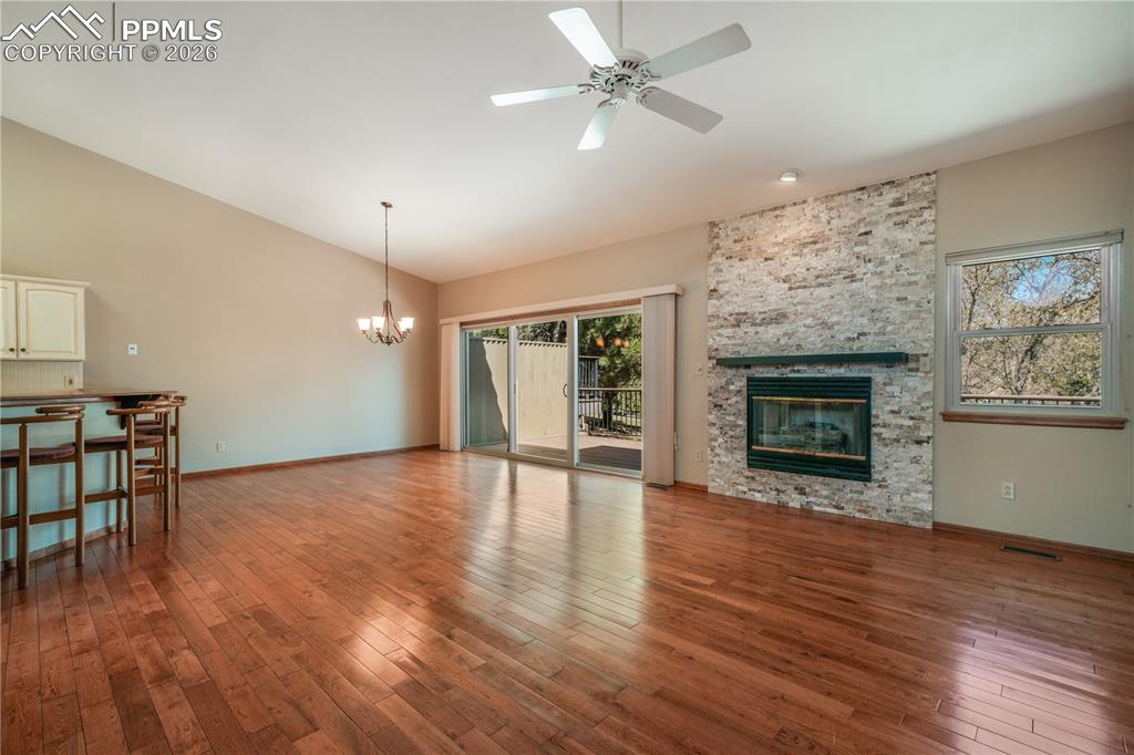 Image 9 of 50: Main living room with hardwood floors, gas fireplace, extended patio doors 