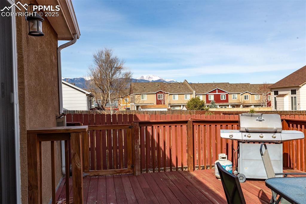 Image 12 of 12: Wooden terrace with a residential view, a mountain view, fence, and grillin