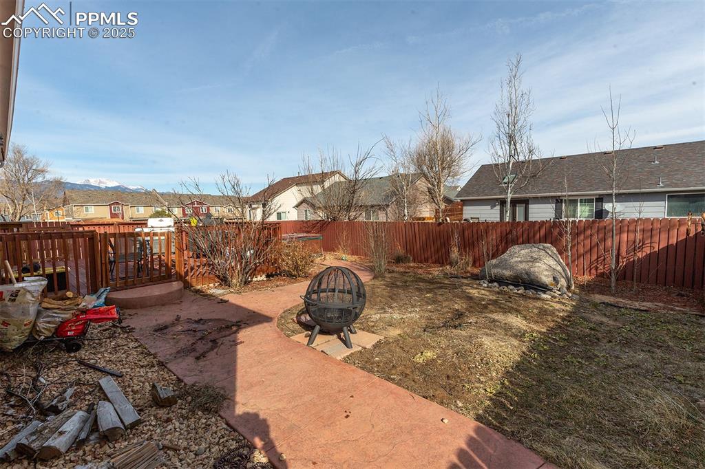 Image 8 of 12: View of yard with a fire pit, a fenced backyard, and a residential view