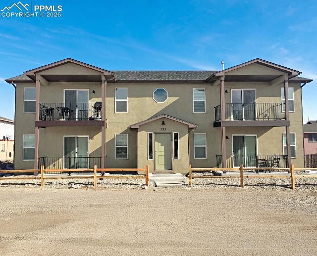 Image 1 of 19: View of front of house with stucco siding, a balcony, and a patio