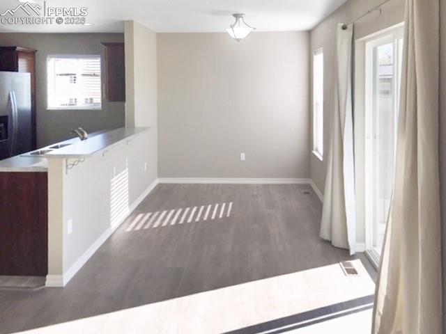 Image 5 of 19: Kitchen featuring light countertops, a peninsula, dark wood finished floors