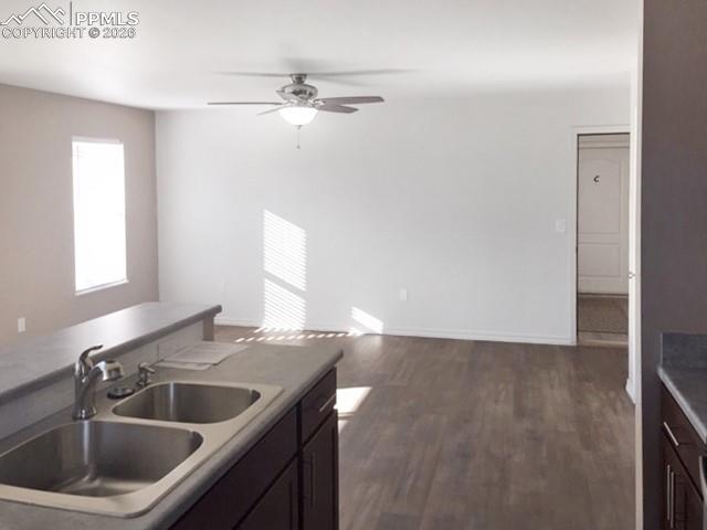 Image 6 of 19: Kitchen with dark wood-type flooring, light countertops, a ceiling fan, dar
