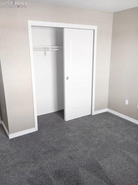 Image 9 of 19: Unfurnished bedroom featuring a closet and dark colored carpet