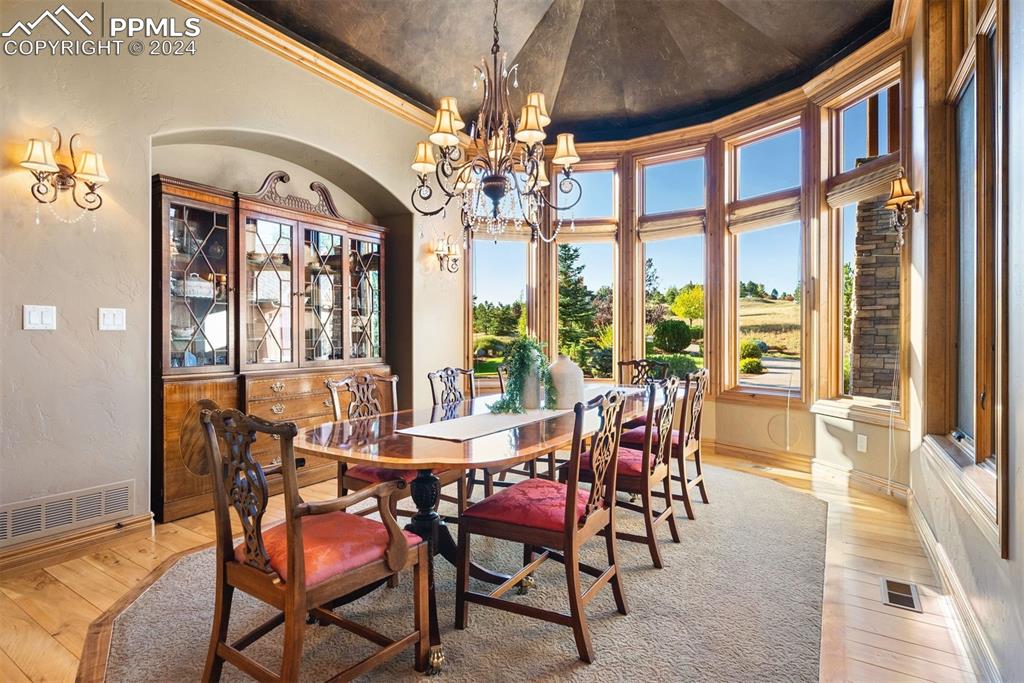 Image 16 of 50: Formal dining room is enhanced by 5 panel bow window & recessed china cabin