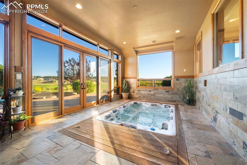 Image 42 of 50: Built in hot tub leads to the outdoor living space and the fire pit, just s