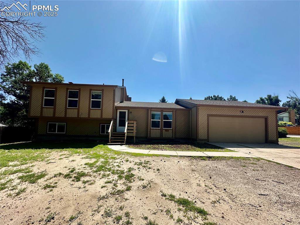 Caption: Tri-level home with an attached garage and driveway