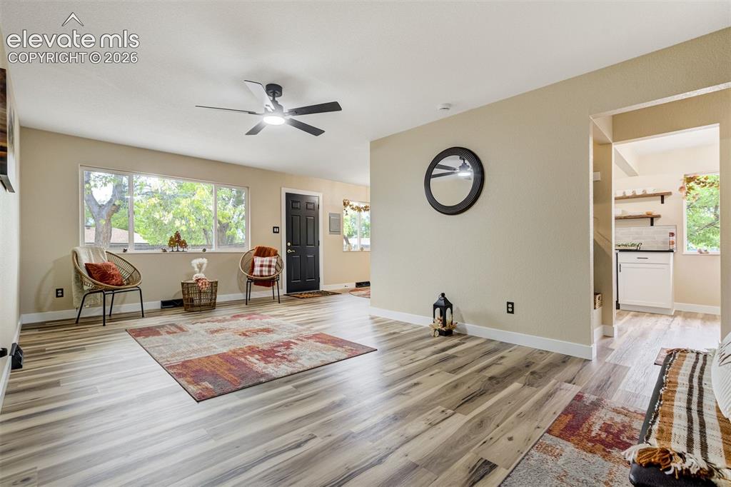 Image 8 of 50: Living room with views of Pikes Peak out the large window. Door leads to th
