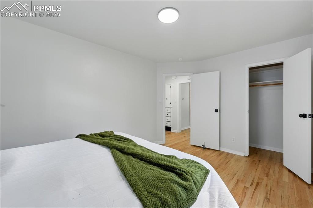 Image 15 of 32: Bedroom with light wood finished floors and a closet