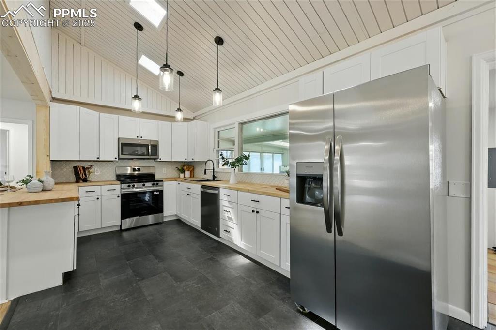 Image 22 of 32: Kitchen with wood counters, appliances with stainless steel finishes, lofte