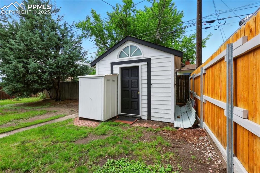 Image 30 of 32: View of shed with a fenced backyard