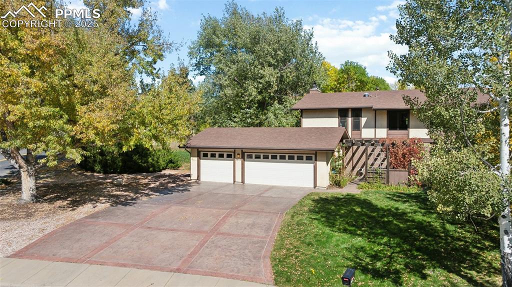 Image 5 of 49: Stamped concrete driveway and 3 car garage