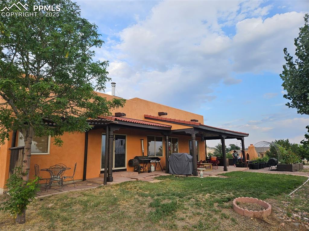 Image 21 of 22: Rear view of property with a patio area, a lawn, stucco siding, and a tiled
