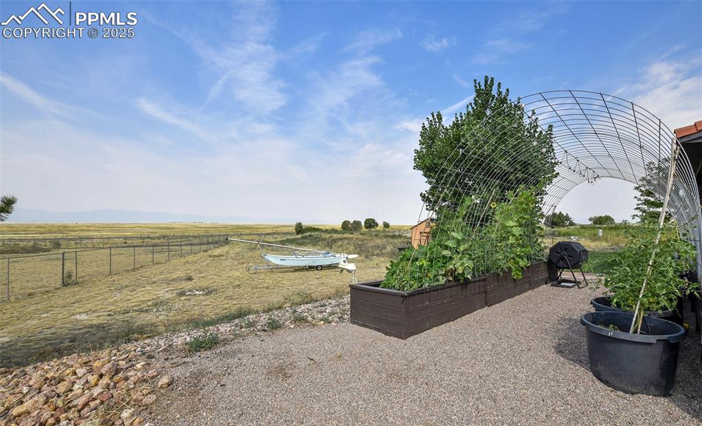 Image 22 of 22: View of yard with a rural view and a vegetable garden