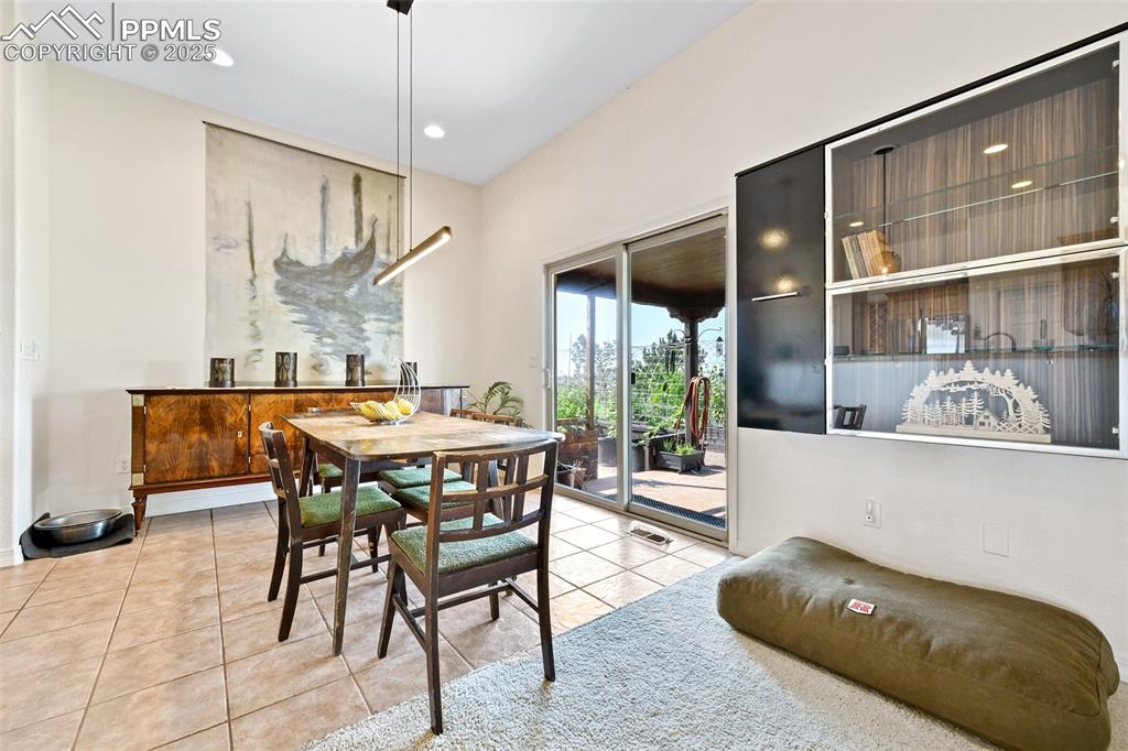 Image 9 of 22: Dining space with light tile patterned flooring and recessed lighting
