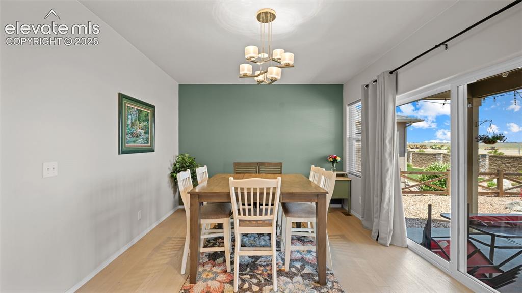 Image 11 of 45: Dining area featuring light wood-finish flooring, a contemporary chandelier