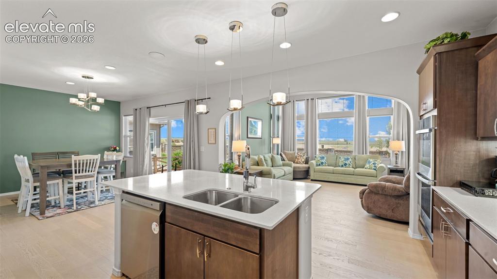 Image 13 of 45: Kitchen island with an undermount double-basin sink and stainless steel dis