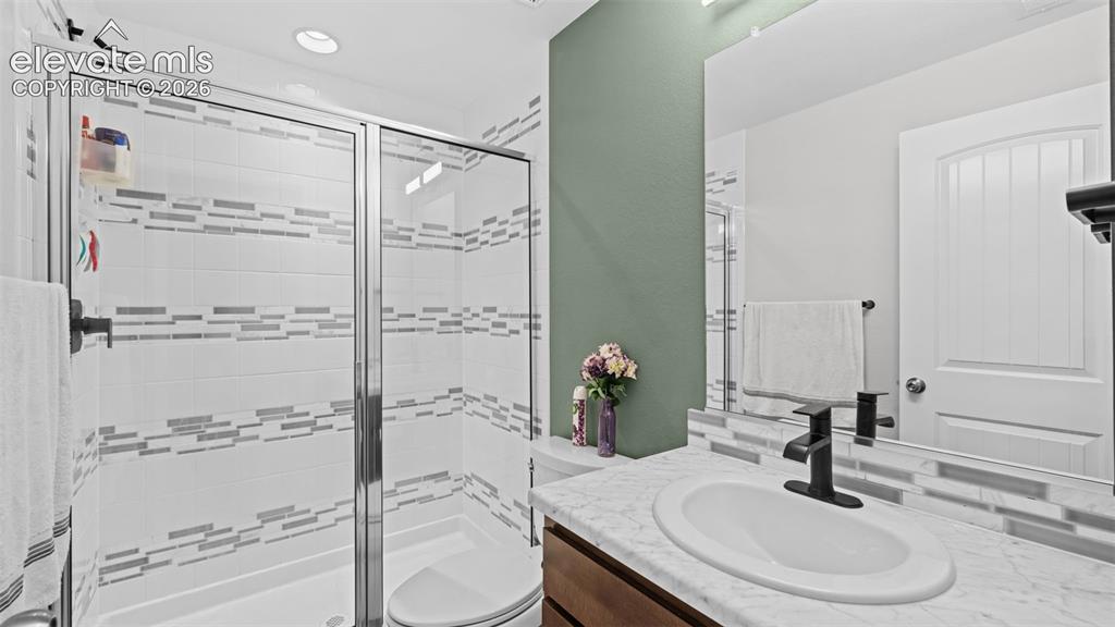 Image 19 of 45: Bathroom featuring a glass-enclosed shower with white and grey horizontal a