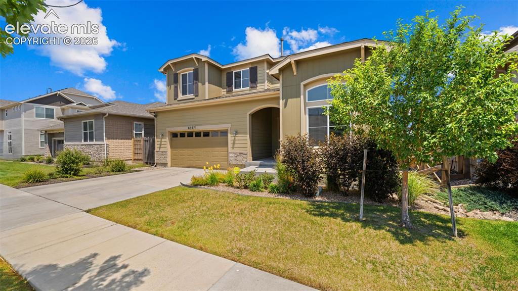 Image 2 of 45: Two-story residence featuring a front-facing garage with a concrete drivewa