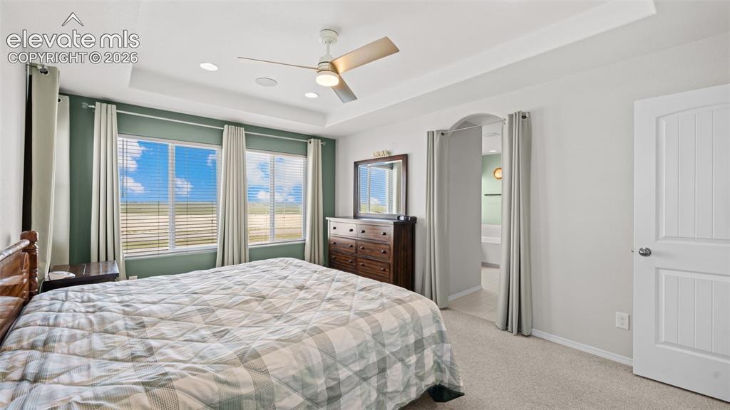 Image 27 of 45: Bedroom with tray ceiling, recessed lighting, and a ceiling fan