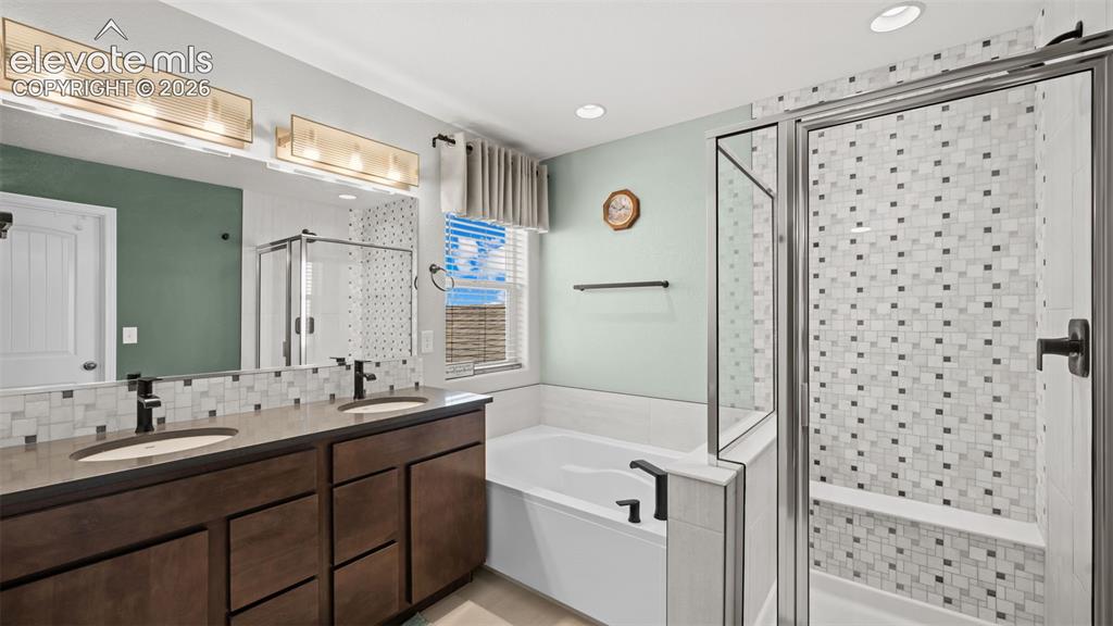 Image 28 of 45: Bathroom featuring a dual vanity with dark wood-finish cabinetry, a freesta