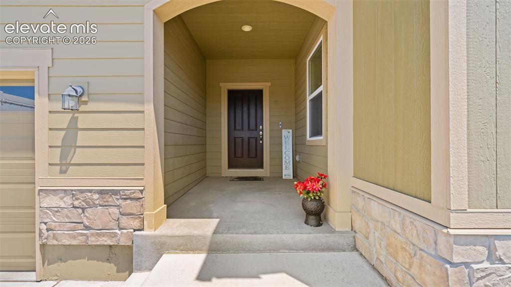 Image 3 of 45: Covered front entry with an arched portico, complemented by a dark paneled 