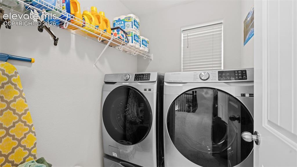 Image 31 of 45: Dedicated laundry area featuring a window with blinds, white wire shelving,