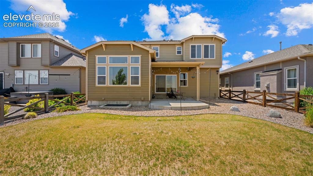 Image 32 of 45: Expansive backyard featuring a patio, sliding glass door access, multiple w