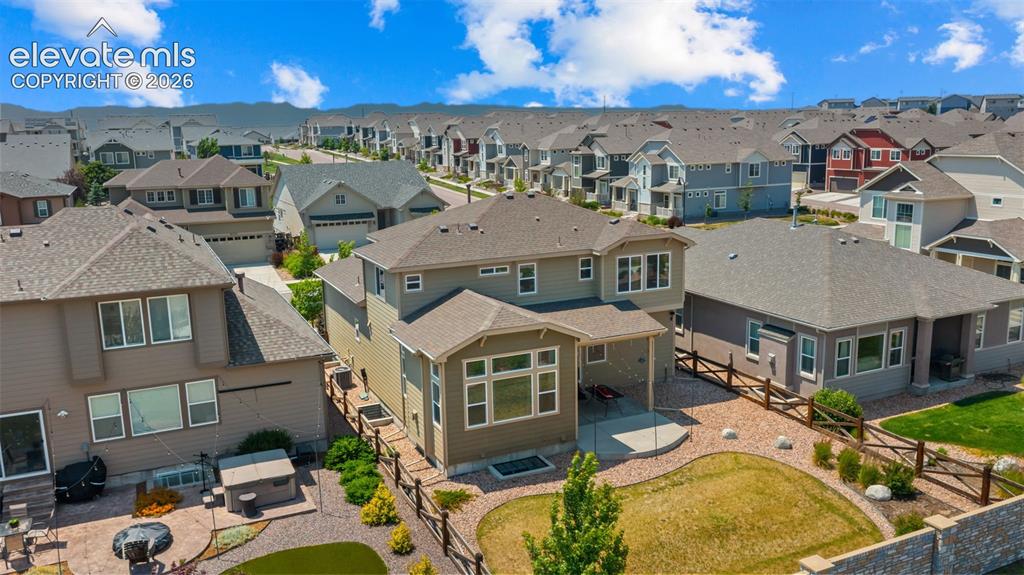 Image 39 of 45: Two-story residence featuring a covered patio, a manicured lawn, and an ext