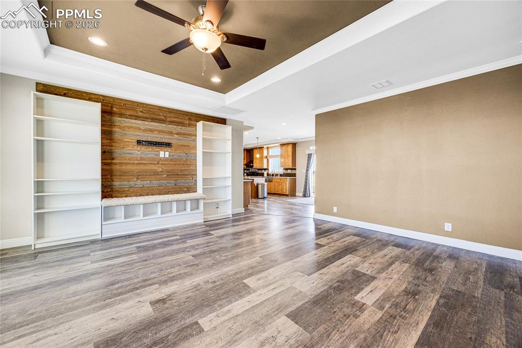 Image 2 of 50: Unfurnished living room featuring a raised ceiling, recessed lighting, orna