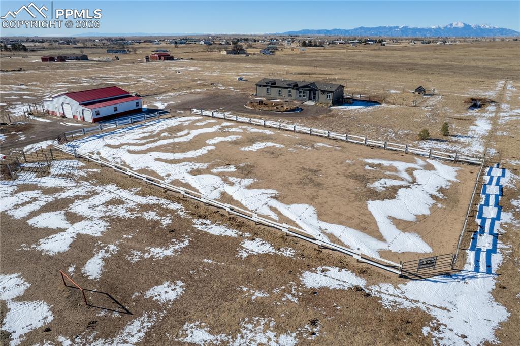 Image 32 of 50: Aerial view of sparsely populated area with a mountain backdrop