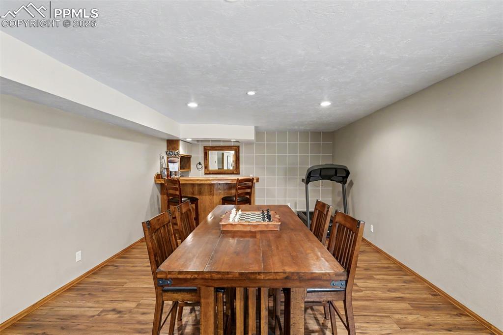 Image 28 of 44: The oversized warm hardwood staircase descends to a finished lower level th