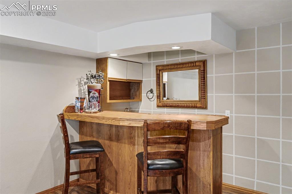 Image 29 of 44: Anchored by a cast iron wood-burning stove set against a stacked stone corn