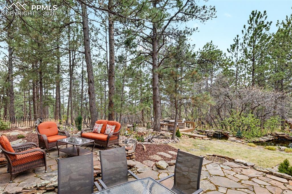 Image 33 of 44: The custom wood wet bar with bar seating, upper cabinets, and a mirror back