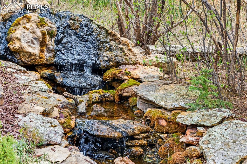 Image 37 of 44: The expansive flagstone patio, with dining table, grill station, and a sepa