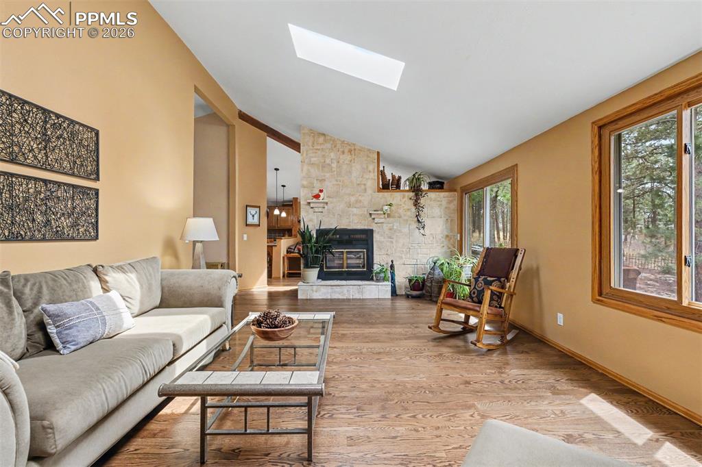 Image 5 of 44: Vaulted ceilings and a skylight bathe the living room in natural light, whi