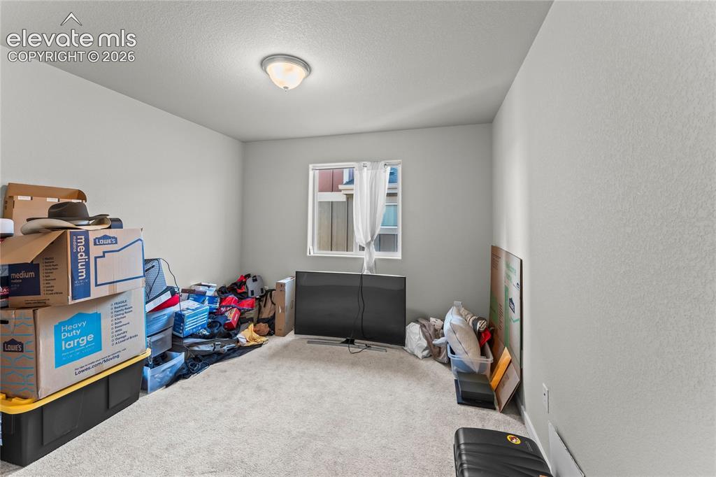 Image 11 of 17: Neutral-toned walls complement the carpeted flooring, creating a versatile 