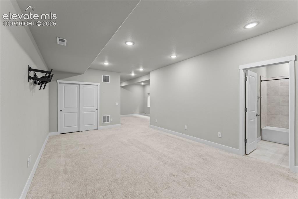 Image 15 of 17: Spacious carpeted room featuring recessed lighting, a closet with sliding d