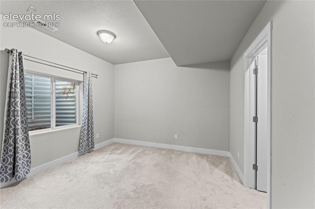 Image 16 of 17: Recessed window with white trim, wall-to-wall carpeting, and a flush-mount