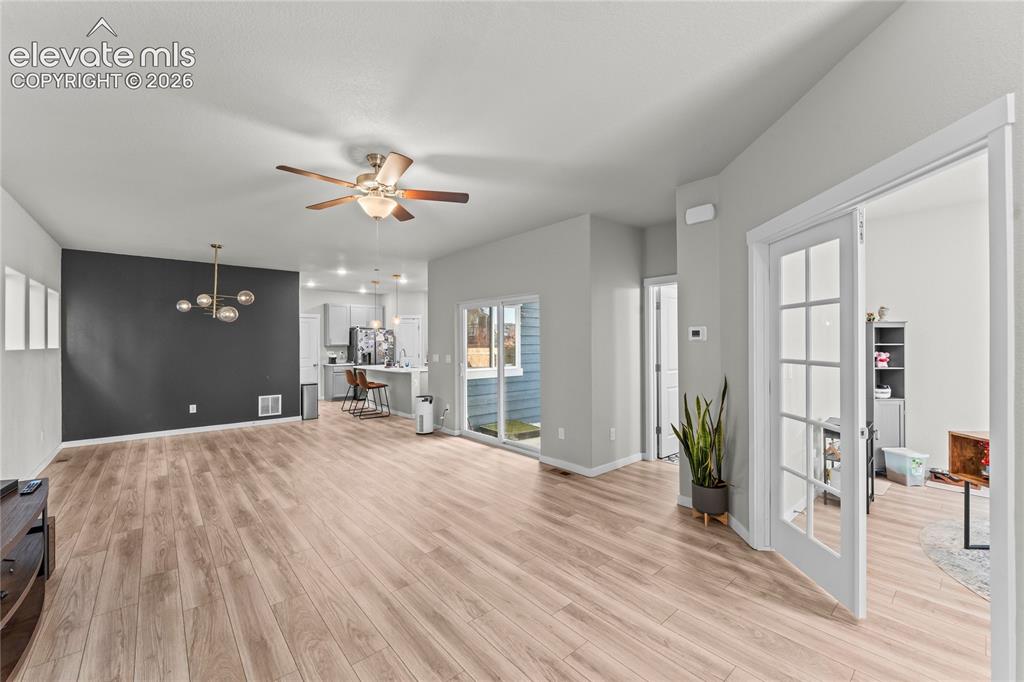 Image 4 of 17: Open-concept living area showcasing wood-finish flooring throughout, a ceil