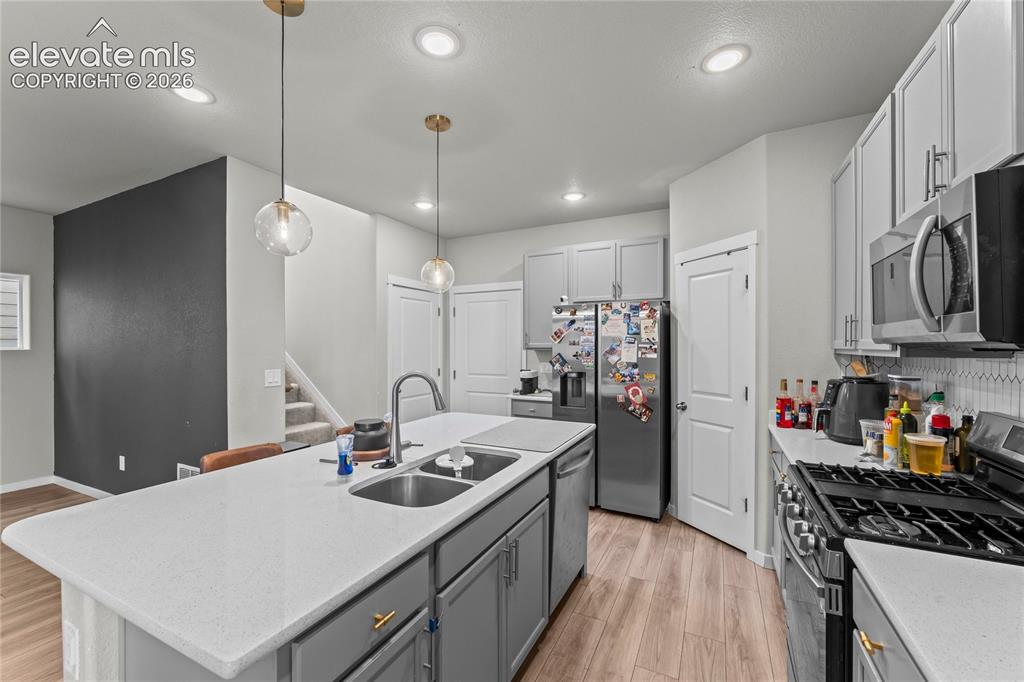 Image 7 of 17: Kitchen featuring a spacious island with dual sinks, light-toned countertop