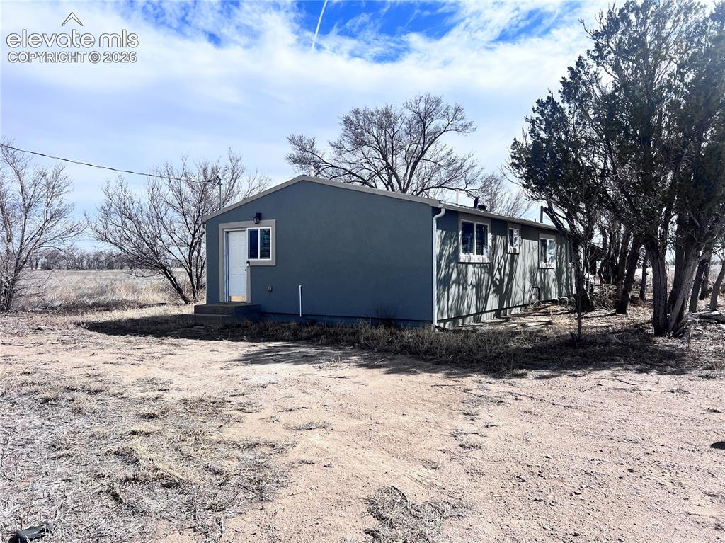 Image 18 of 49: Single-story structure with a low-slope roof, light blue exterior siding, a