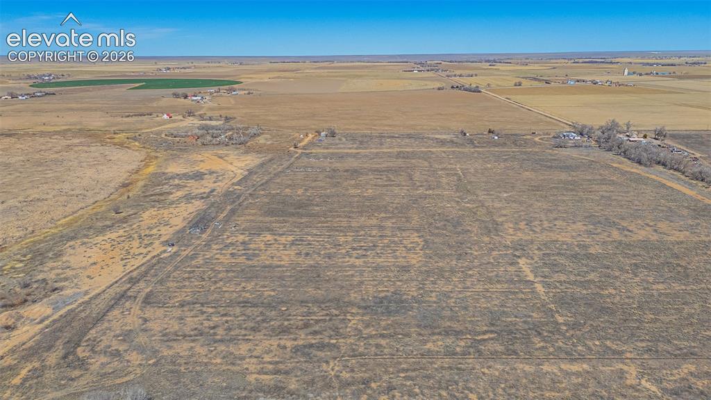 Image 42 of 49: Expansive undeveloped land featuring a clear horizon and distant agricultur