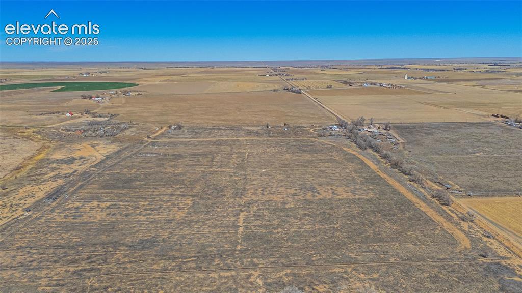 Image 47 of 49: Expansive acreage featuring open fields and distant structures