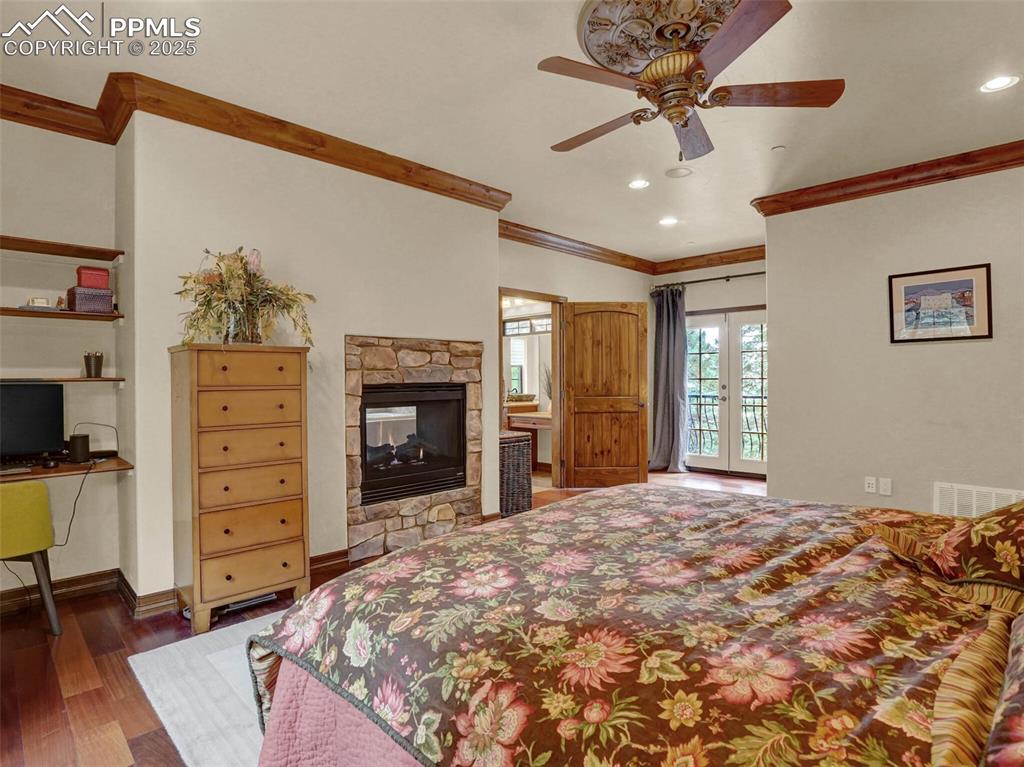 Image 28 of 37: Primary Bedroom with dual fireplace and french doors to balcony
