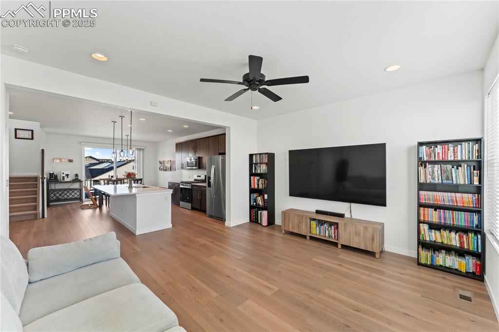 Image 15 of 31: Living room with light wood-style floors, recessed lighting, ceiling fan, a